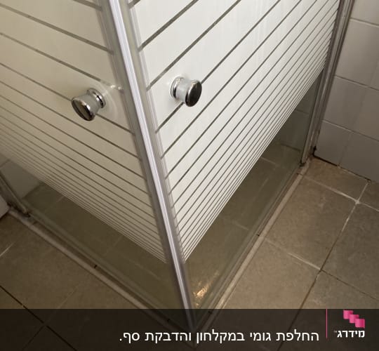 מקלחון עם דלתות זכוכית ורצפת קרמיקה